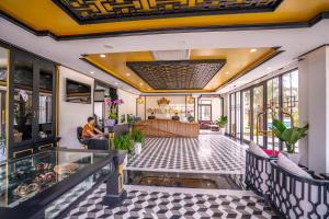 a lobby of a hotel with a reception area at Fivitel Hoi An Hotel in Hoi An