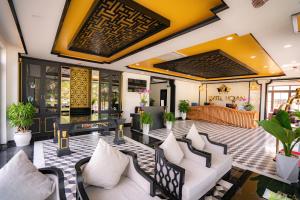 a lobby of a restaurant with couches and tables at Fivitel Hoi An Hotel in Hoi An