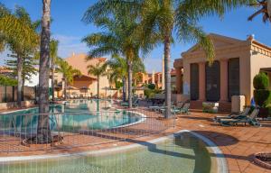 a swimming pool with palm trees in a resort at B27 - LuzBay 2 Bed Apartment in Luz