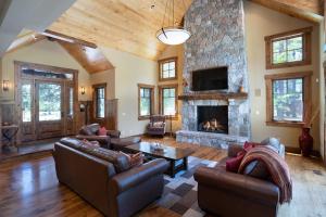 un soggiorno con mobili in pelle e camino in pietra di Luxury 4BD Residence on Old Greenwood Golf Course. Free Grocery Delivery! a Truckee