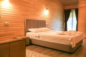 A bed or beds in a room at Cinderella Pension & Bungalow