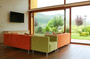 a living room with couches and a flat screen tv at Posada Cabárceno in Cabárceno