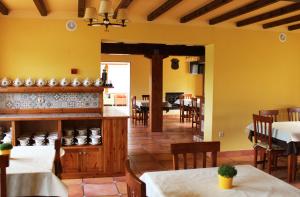 a restaurant with yellow walls and tables and chairs at Posada Cabárceno in Cabarceno