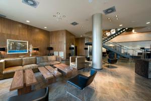 vestíbulo con sofá, mesas y escalera en Hotel Badalona Tower en Badalona