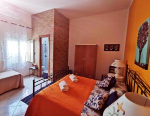 a bedroom with a bed with an orange bedspread at Il Pescatore in Marinella di Selinunte