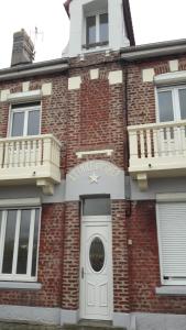 a brick building with a white door and balcony at imperatrice 2 in Berck-sur-Mer