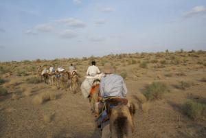 a group of people riding horses in the desert at Ganesh Guest House in Jaisalmer