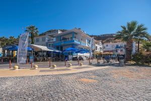 een geplaveide straat in een stad met gebouwen en palmbomen bij Villa Vongole in Çeşme