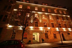 un edificio illuminato con un'auto parcheggiata di fronte di Apart Hotel Susa a Praga