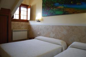 a bedroom with two beds and a painting on the wall at Posada Cabárceno in Cabarceno