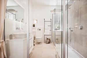 a white bathroom with a shower and a sink at S&G Corfu Old Town Apartments - The Volto Suite in Corfu