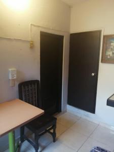 une chambre avec une table et une porte noire dans l'établissement Hotel Puerto Viejo, à Mazatlán