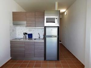 a kitchen with a refrigerator and a microwave at Two Lofts in Matalascañas