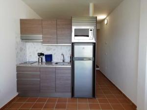 a kitchen with a refrigerator and a microwave at Two Lofts in Matalascañas +31 photos