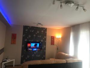 ハイドゥソボスローにあるTommy Apartman 2.0のリビングルーム(ソファ、壁掛けテレビ付)