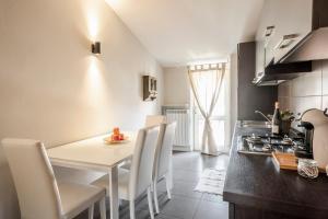 una cucina e una sala da pranzo con tavolo e sedie di L'Angelica Holiday Home a Desenzano del Garda