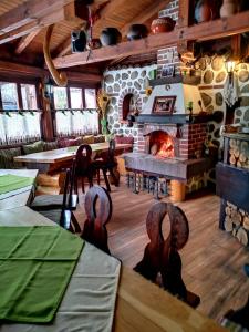 a large room with a fireplace and tables and chairs at Zigen House in Bansko