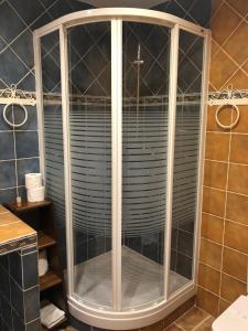 y baño con ducha y ventana con persianas. en Micro-Hostal La Puerta del Perdón en Villafranca del Bierzo