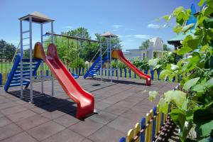 un parque infantil con toboganes rojos y azules y un columpio en Hotel Stefanov 1, en Lozenets