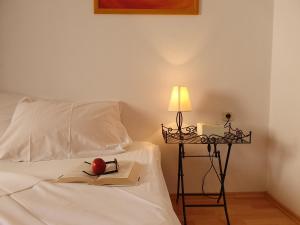 una cama con una manzana en un libro y una lámpara en Central Gem - ZF Hvar House, en Hvar