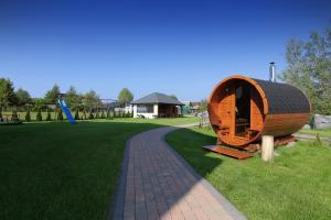 a wooden boat sitting on the grass in a park at Trzy Czajki Dom Gościnny in Wicie