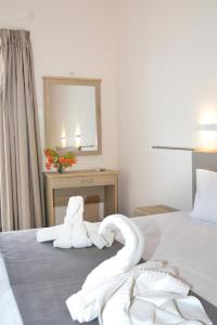 a hotel room with a bed with white towels on it at GOLDEN STAR in Agia Marina Aegina
