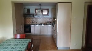 a kitchen with white cabinets and a table in a room at BG Villa, Apartment L in Sutomore