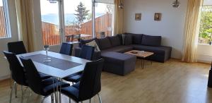 a living room with a couch and a table with chairs at Beautiful house just 50 m from the sea in Hólmavík