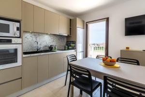 a kitchen with a table with chairs and a microwave at Domaine A Marella in LʼÎle-Rousse