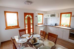 a kitchen with a table and chairs in a kitchen at Panoráma Csopak in Csopak