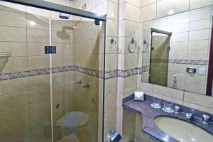 a bathroom with a shower and a sink and a mirror at Don Antonio Hotel in Ceres