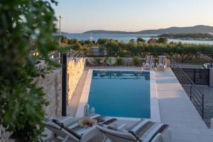 una piscina con tumbonas y vistas al agua en Villa Croatica II, en Šibenik