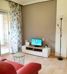 a living room with a tv on a white cabinet at Apartamento Cervantes in Guardamar del Segura