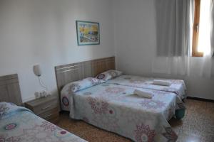 1 dormitorio con 2 camas y ventana en Pension Eva, en Puerto de Mogán