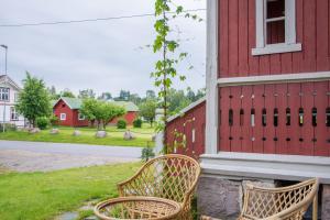 two chairs sitting outside of a red building at lunde slusevaktarbolig in Lunde +11 photos
