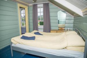 a bed in a room with green walls and a window at lunde slusevaktarbolig in Lunde