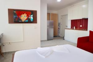a room with a white bed and a kitchen at Dua Apartments in Shëngjin