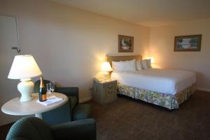 Habitación de hotel con cama y mesa con lámpara en Sandcastle Resort at Lido Beach, en Sarasota