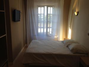a bed in a room with a window at Hotel Le Bristol in Valenciennes