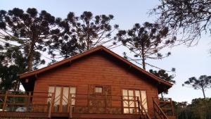 a small wooden cabin with trees in the background at Celeiro das Águas Brancas in Urubici