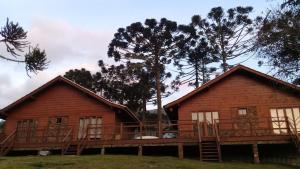 a log cabin with a large deck in front at Celeiro das Águas Brancas in Urubici