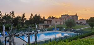 a swimming pool with chairs and a house in the background at Agriturismo Diaccialone in Istia dʼOmbrone
