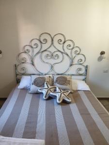 a bed with a metal headboard with two star cushions at Residence Porto Rotondo in Porto Rotondo