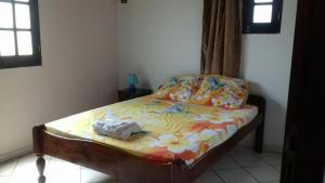 uma pequena cama num quarto com em T3 Bel Enclos SCHOELCHER Kybo Karaib Location Vue mer Calme em Schœlcher