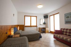 sala de estar con cama y sofá en Max Meublè, en Castione della Presolana