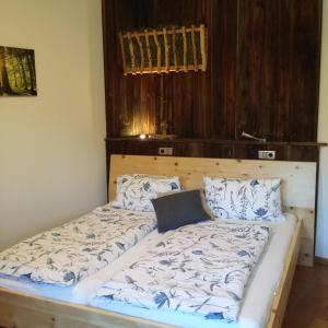 Schlafzimmer mit einem Bett mit einem Kopfteil aus Holz in der Unterkunft Biohof Köck Tonibauer in Zeutschach