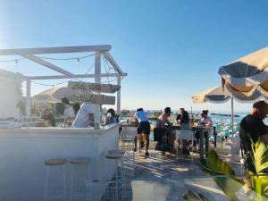 un grupo de personas sentadas en un bar en la playa en Hotel Doge, en Rímini