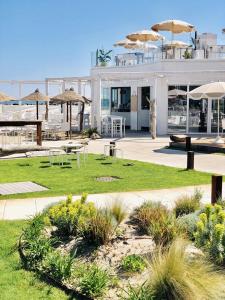 a building with tables and chairs and umbrellas at Hotel Doge in Rimini