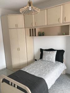 um pequeno quarto com uma cama e armários brancos em Apartamento céntrico Santa Cruz de Tenerife em Santa Cruz de Tenerife