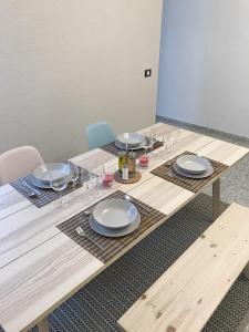 uma mesa de madeira com pratos e copos de vinho em Apartamento céntrico Santa Cruz de Tenerife em Santa Cruz de Tenerife